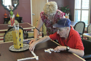 elderly couple playing dominoes together